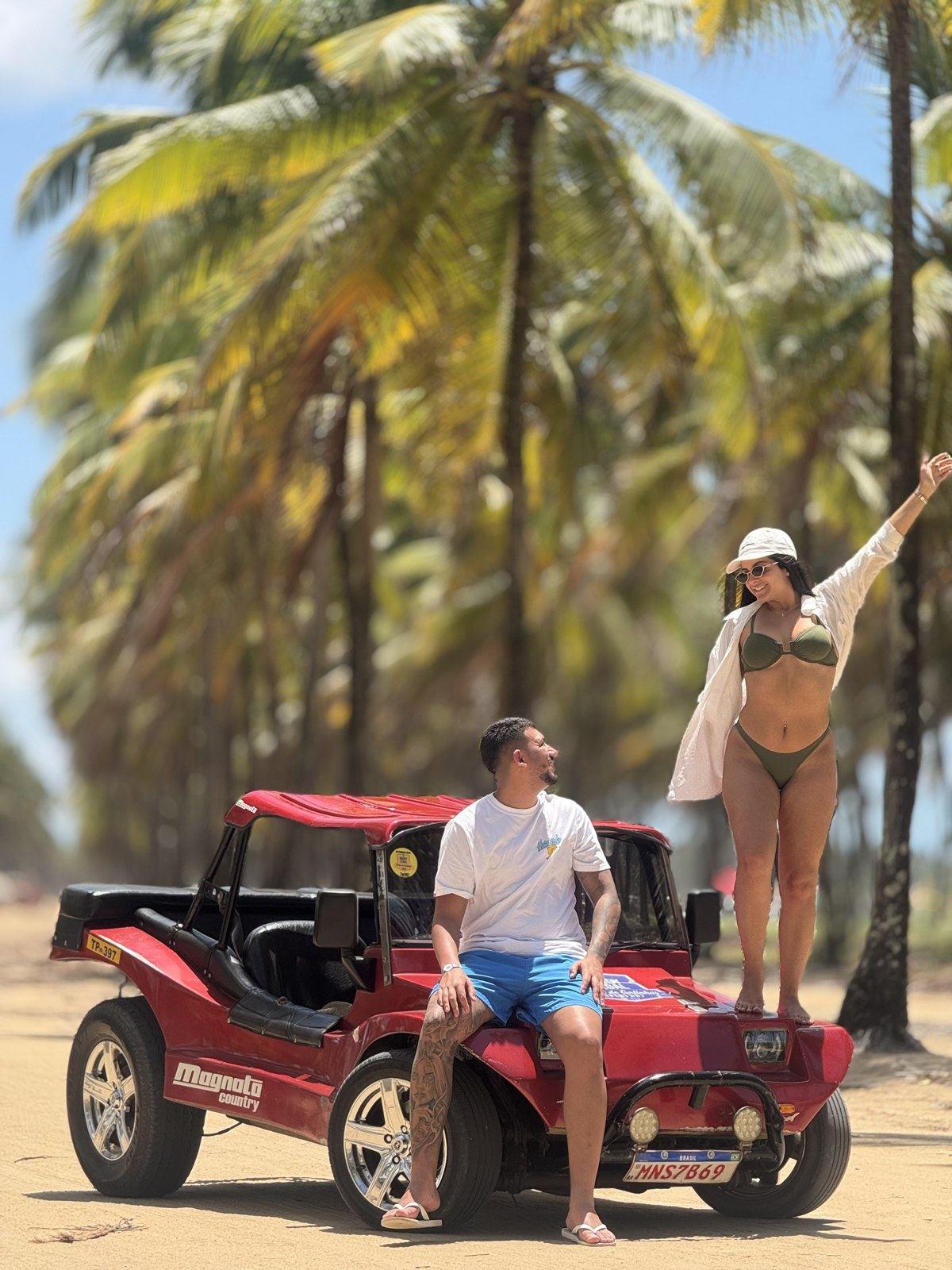 Casal com o buggy vermelho Magnata no coqueiral